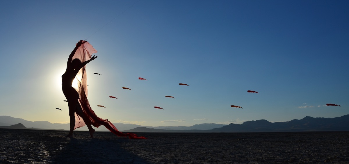 Ruth Whiting in the desert with a triangle installation of Flowx Kites designed by WindFire Designs