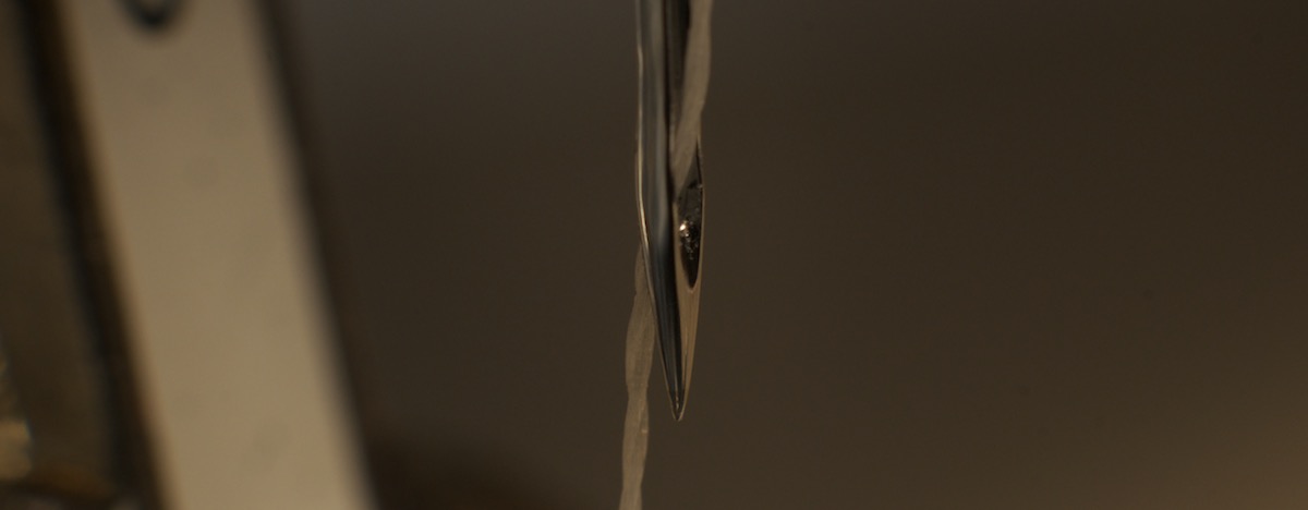 sewing needle showing polyester thread