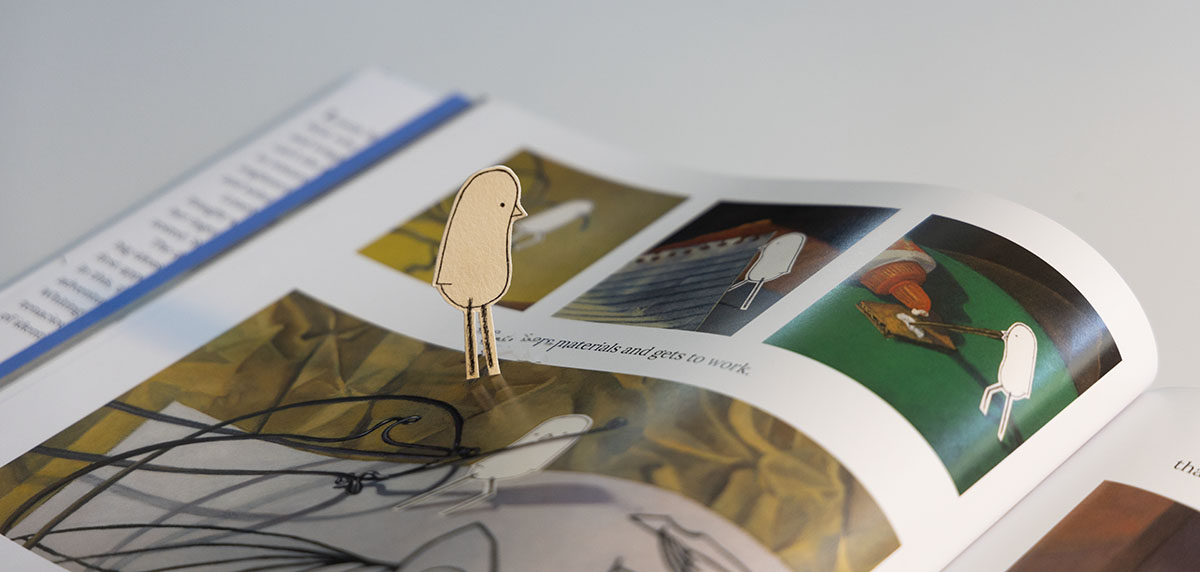 an image of Lonely Bird looking at the pages of the second Lonely Bird Book called Lonely Bird's Dream by Ruth Whiting