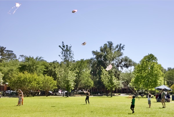 group kite flying in a field after kite making workshop by Sarah Lucas and WindFire Designs